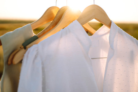 Summer dresses on a hanger at sunset. Summer, beauty, fashion, glamor, lifestyle concept.の写真素材