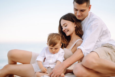 Cheerful young family with little baby boy spending time together on the beach.の写真素材