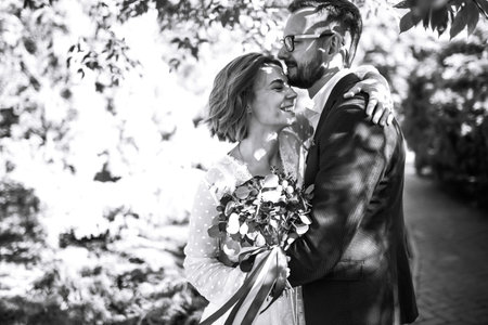 Beautiful black and white photo of bride and groom. Happy couple posing and smiling in wedding dressの写真素材