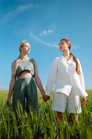 Two Beautiful woman in the green field. Nature, vacation, relax and lifestyle. summer landscape.の写真素材
