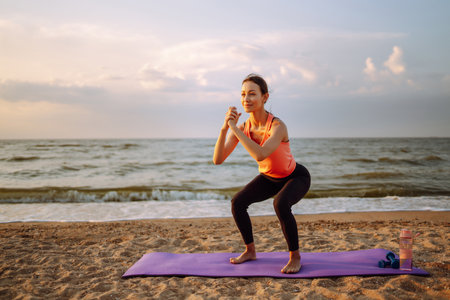 Young woman in sportswear doing yoga, fitness exercise on the beach. Sport, Active life.の写真素材