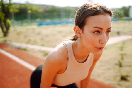 Young woman in sports outfit doing exercises outdoors in the morning. Sport, Active life sports trainingの素材 [FY310206835981]