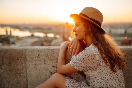 Portrait of happy tourist in hat at dawn enjoys cityscape. Traveling in Europe. concept tourism.の写真素材