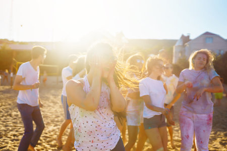 A group of friends have fun, dance at the holi festival. Spring Beach Party. Friendship, Leisure, Togetherness.の写真素材