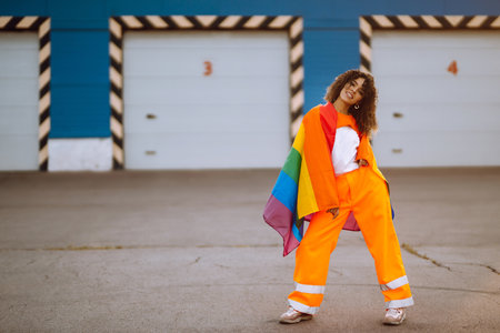 African American lesbian woman holding LGBT rainbow flag. The concept of happiness, freedom and love...