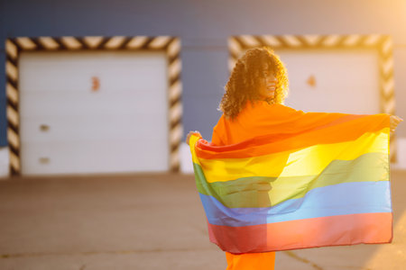 African American lesbian woman holding LGBT rainbow flag. The concept of happiness, freedom and love for same-sex couples.の写真素材