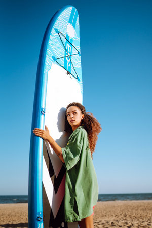 Woman surfer walks with a board on the sandy beach. extreme sport. Travel, weekend, lifestyle.の写真素材