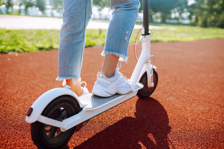 Legs of woman riding electric kick scooter. Ecological transportation concept.の写真素材
