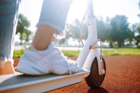 Legs of woman riding electric kick scooter. Ecological transportation concept.の写真素材