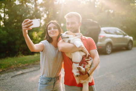 selfie time. ?ouple together with their beloved pet on walk doing selfie. Active lifestyle concept.の写真素材