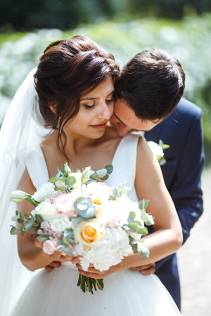 The bride and groom walk together in the park. Pretty bride and stylish groom. wedding day. Marriage.の写真素材