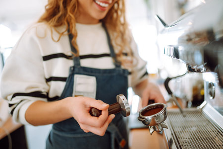 Female barista making coffee in a coffee machine. Conception of business and service. takeaway food.の写真素材