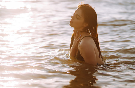 Young woman walks along the seashore at sunset. Nature, relax, lifestyle concept.