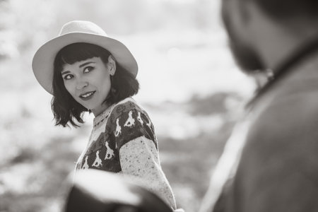 black and white photos. Lovely hipster couple with bike. couple wearing beautiful hats and sweatersの写真素材