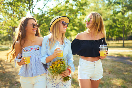 Three nice girls having fun In the park and make selfie. Excellent sunny weather. Beautiful figures.