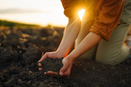 Woman farmer's hand touch soil, check her health before growing vegetables. concept of agriculture.の写真素材