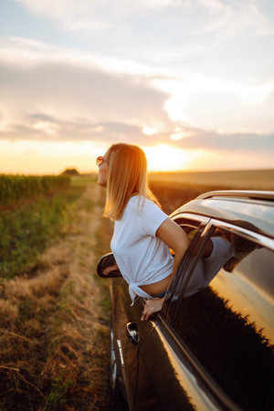 lifestyle! Tourist woman rests and leans out of car window, enjoys trip. Travel concept, vacation.の写真素材