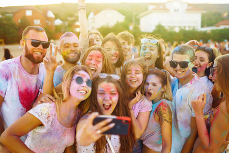Time for a selfie! Teenagers Friends have fun at the holi festival. Celebrating traditional Indian holiday.の写真素材