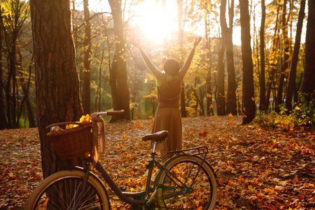 Happy young woman having fun with leaves in autumn park.の写真素材