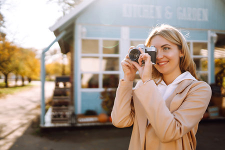 Young girl with retro camera enjoying autumn weather.