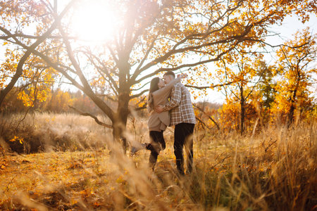 Happy couple in love newlyweds in casual clothes travel together, hike and walk in autumn forest.の写真素材