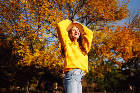 Young woman in a yellow sweater and jeans resting in nature. Fashion, style concept. People,...
