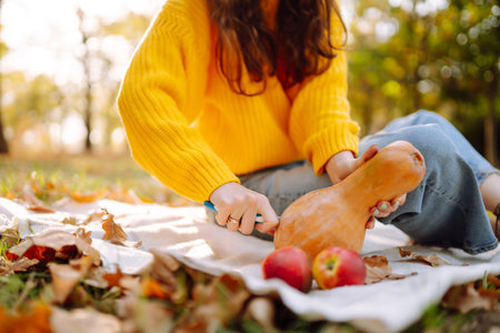 Fall picnic with pumpkin. Stylish woman enjoying autumn weather in the park. autumn harvest.の写真素材