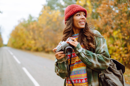 Beautiful young woman is photographed with a retro camera. Rest, relaxation, travel, lifestyle...