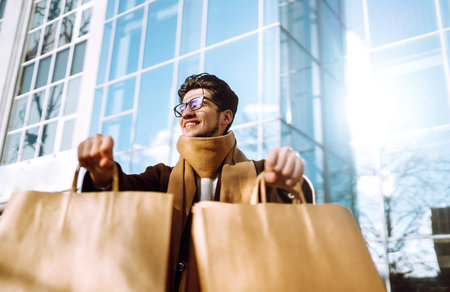 Stylish man with paper packages after shopping. Sale, consumerist, lifestyle concept.の写真素材