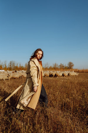 Stylish young woman posing in a field. Fashion, glamor, lifestyle concept. Autumn.の写真素材