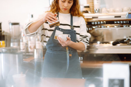 Female barista making coffee in a coffee machine. Conception of business and service. takeaway food.の写真素材