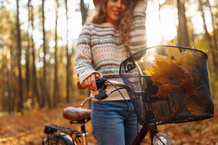 Happy active young woman on bike in autumn park at sunset. Concept of people, recreation, active...