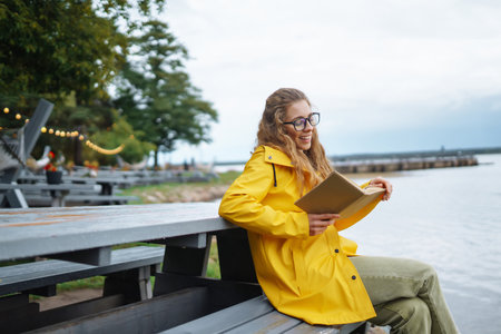 Beautiful woman is enjoying fresh air and reading book. Concept of relaxation, lifestyle.の写真素材