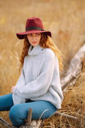 Stylish woman in hat enjoying autumn weather in the park. Fashion, style concept.の写真素材