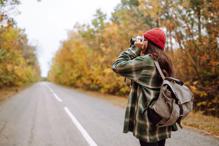Beautiful young woman is photographed with a retro camera. Rest, relaxation, travel, lifestyle conceptの写真素材
