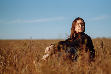 Stylish young woman posing in a field. Fashion, glamor, lifestyle concept. Autumn.