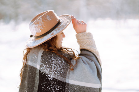 Beautiful woman standing among snowy trees and enjoying first snow. Happy winter time. Christmas.の写真素材