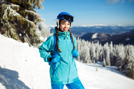 Girl in winter clothes drinking tea on the background of snow-capped mountains on the sunny day.の写真素材