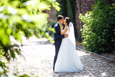 The bride and groom walk together in the park. Pretty bride and stylish groom. Wedding day. Marriage.の写真素材