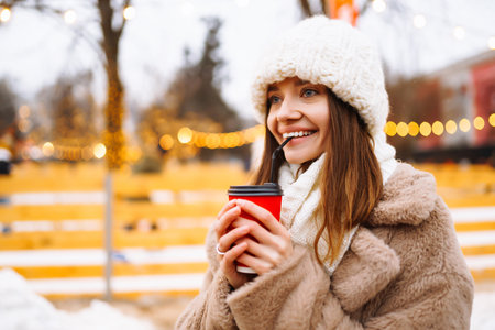Young woman in winter style clothes posing at festive street market. Woman enjoying winter moments.の写真素材
