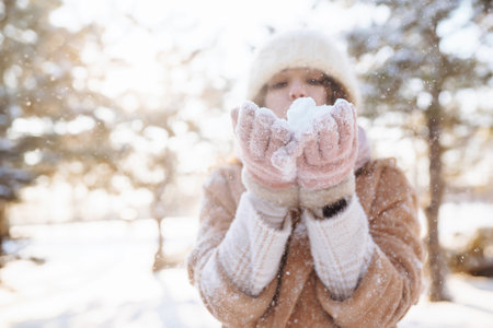 Happy woman walking in the snowy winter day outdoor. Winter fashion, holidays, rest, travel concept.の写真素材