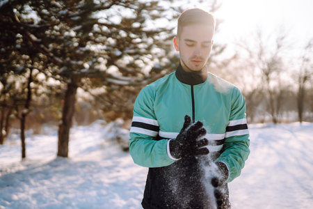 Young sportsman doing workout in forest at snowy winter day. Outdoor fitness, cardio exercises.の写真素材