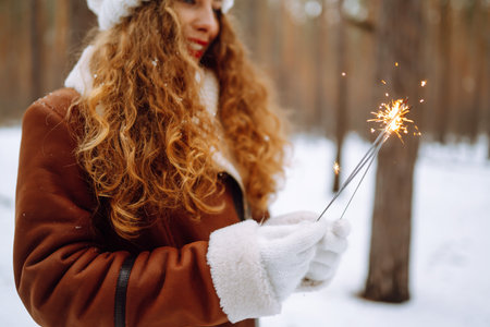 Happy woman with Bengal light in her hand enjoying and have fun winter holidays among snowy landace.の写真素材