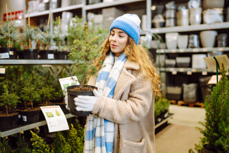 Beautiful young woman buys a Christmas tree at the fair. New Year's holiday conceptの写真素材