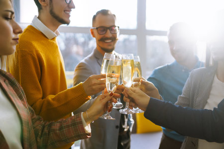 Clinking glasses with champagne. Happy coworkers celebrating their business achievement.