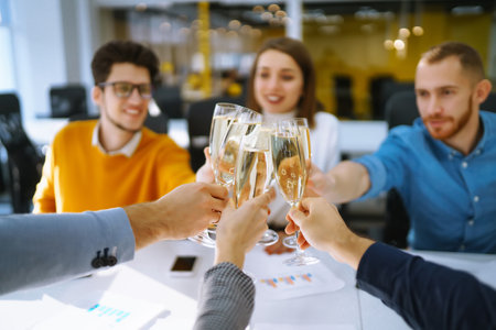 Clinking glasses with champagne. Happy coworkers celebrating their business achievement.