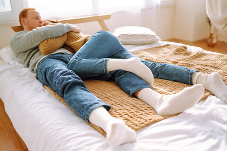Couple in love relaxing at home on bed while they hug each other. Valentine's Day, holiday concept.
