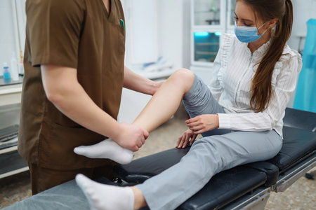 Doctor examining female patient with injured leg. Osteopathy, Chiropractic leg adjustment.の写真素材