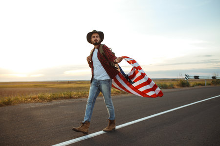 Traveler with the flag of America. The man in a hat, a backpack, a shirt and jeans.