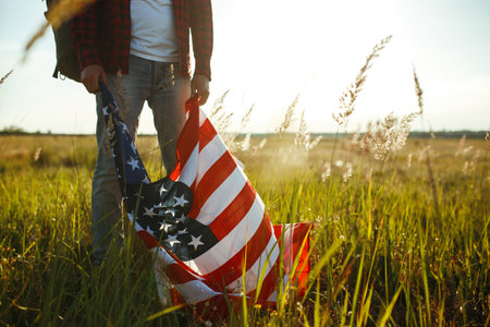 Traveler with the flag of America. The man in a shirt and jeans.